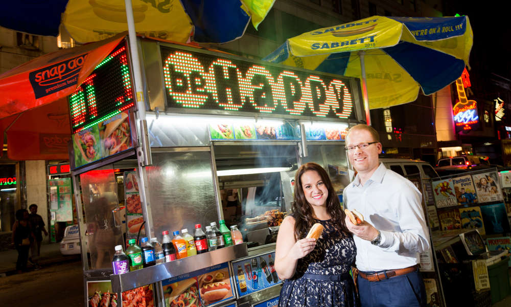 photo of Samara & David at a hotdog stand in Times Square